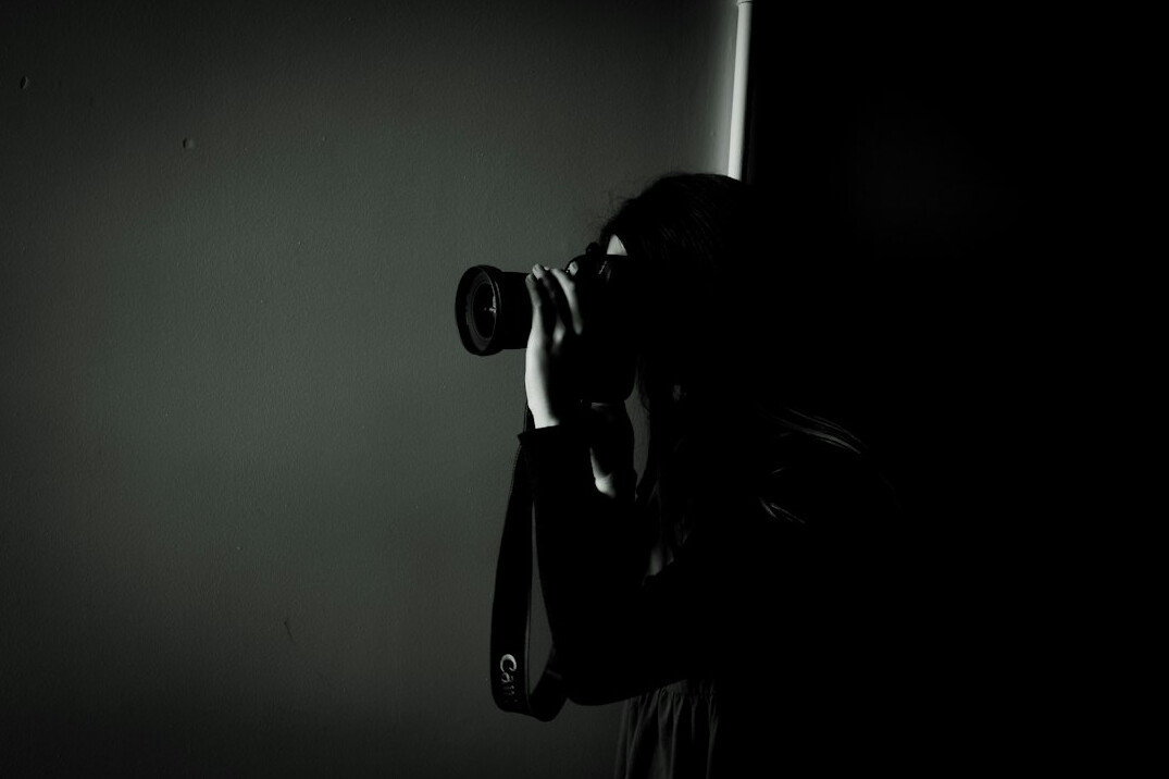 Camera operator filming a live television news broadcast in a studio